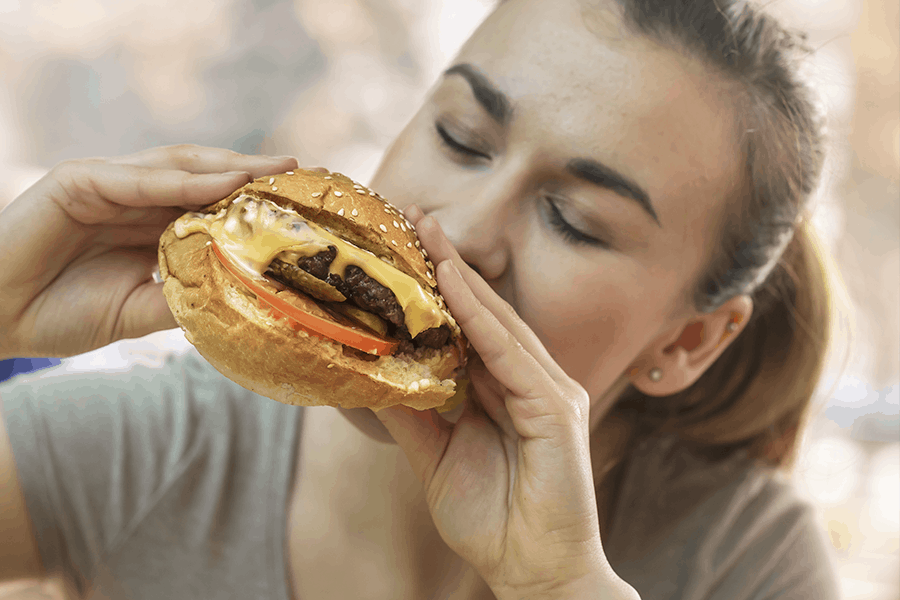 Woman eats large cheeseburger which could exacerbate her GERD